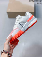 Side view of the white low-top sneaker with On branding, pink forefoot panel, orange heel accent and orange outsole.