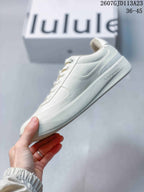 Side profile of the white lululemon sneaker showing the low-top shape, lace-up construction, tonal side branding, and layered sole.
