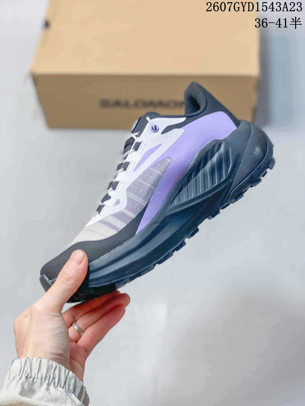 Side profile of a Salomon Genesis trail running shoe with purple and white overlays and a black midsole.