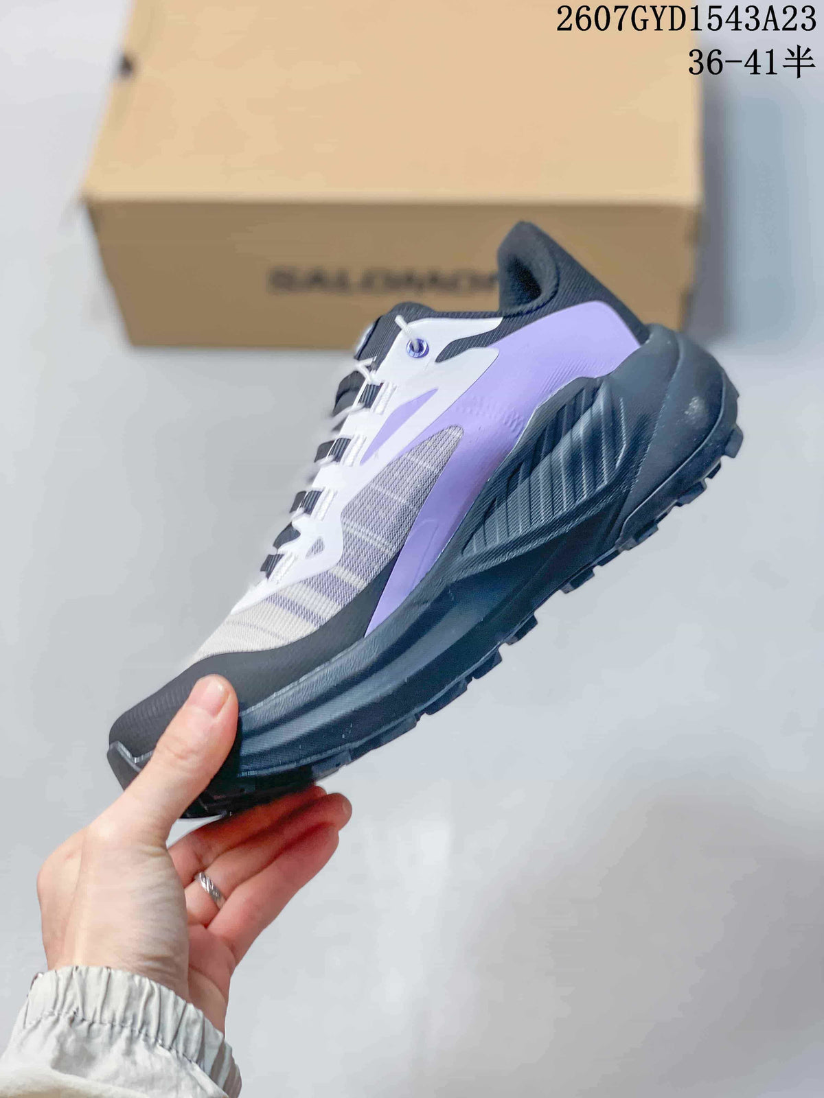 Side profile of a Salomon Genesis trail running shoe with purple and white overlays and a black midsole.