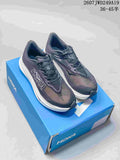 Pair of dark Hoka running shoes displayed on a blue shoe box, showing the mesh upper, white midsole and visible style code text.