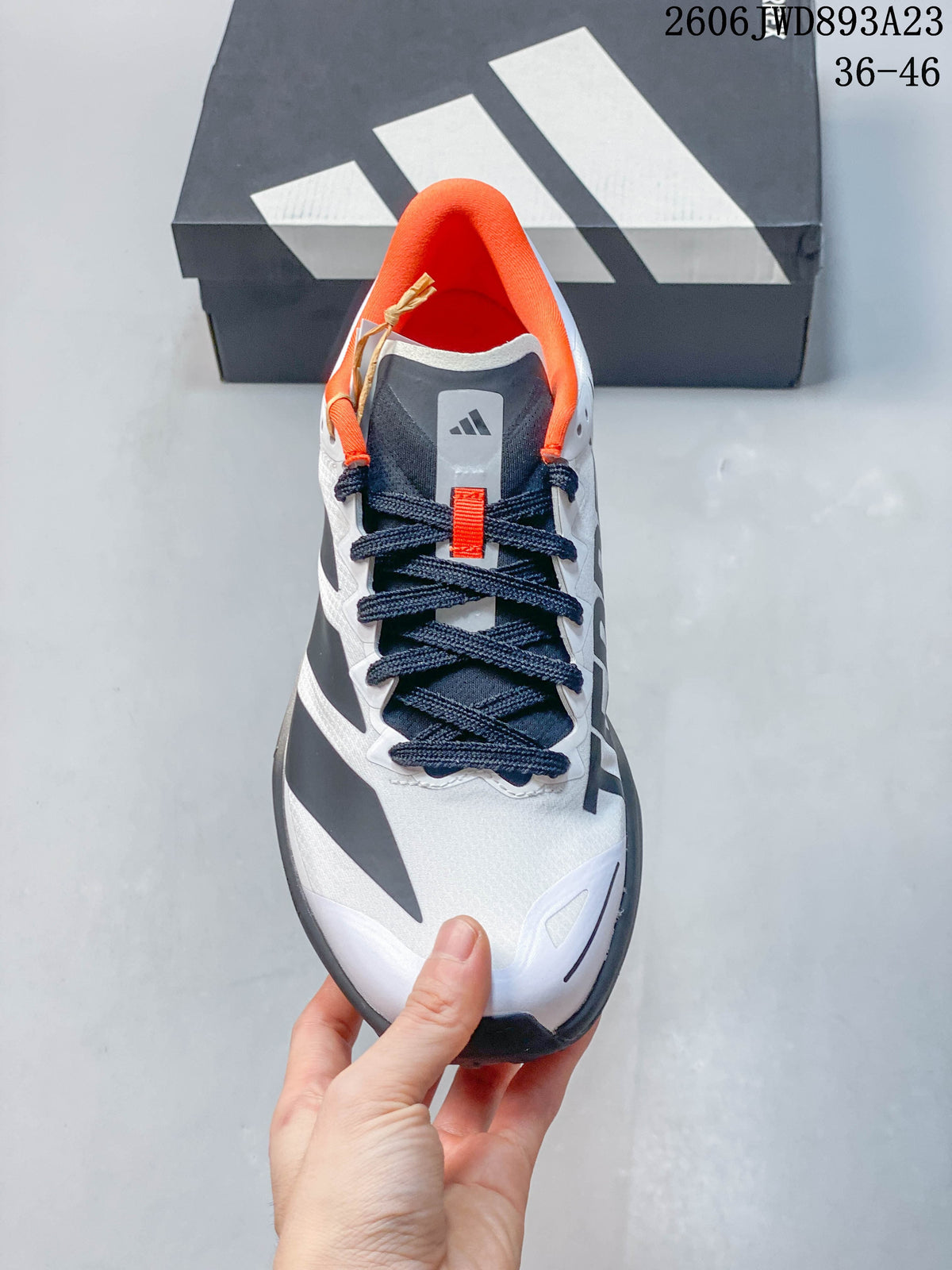 Top view showing the shoe's laces, tongue, and orange collar lining.