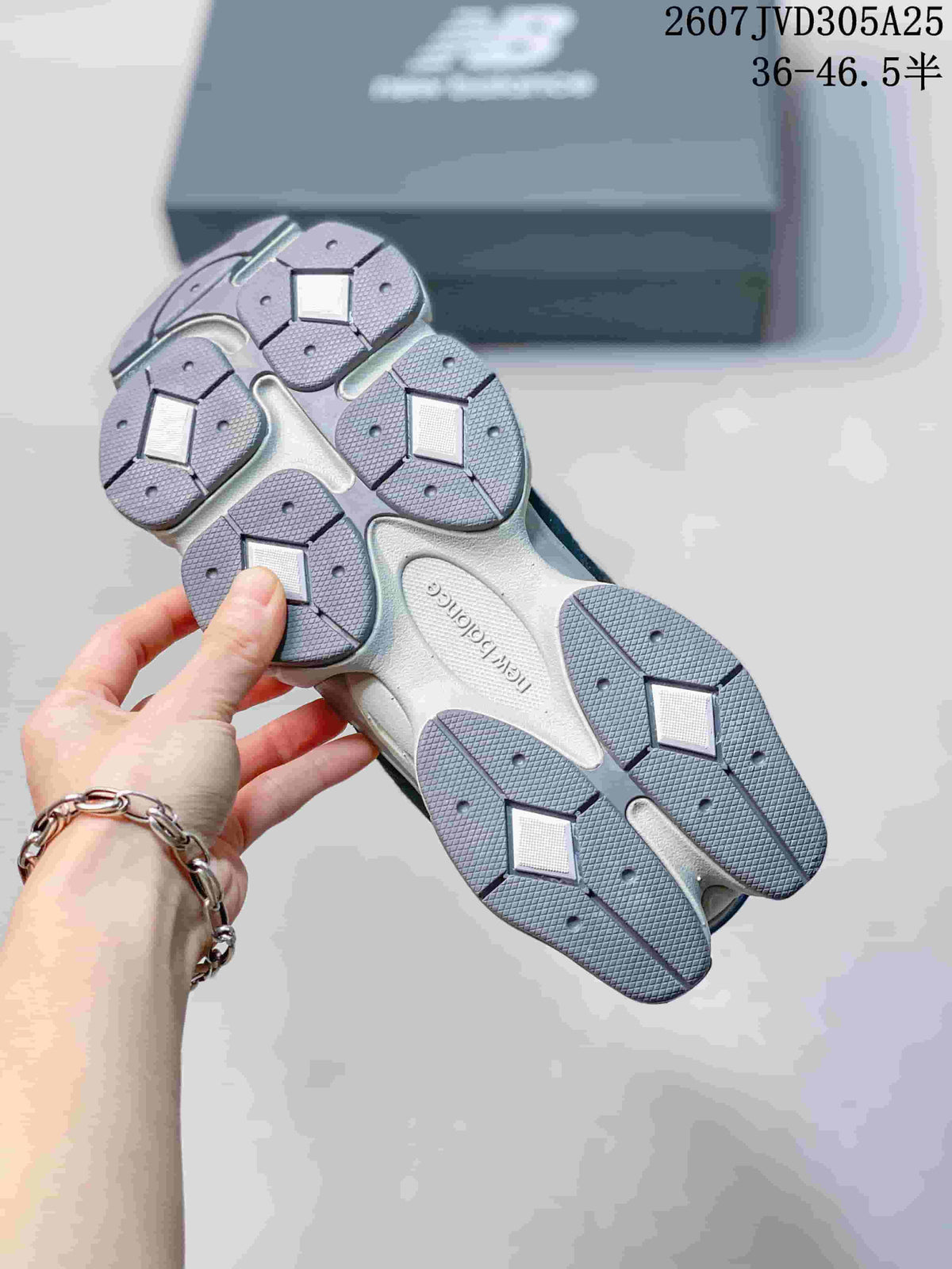 Underside view showing the segmented grey outsole and tread pattern of the sneakers.