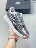 Side view of a metallic silver low-top sneaker with a white outsole.