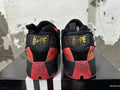 Rear view of red and black BAPE and adidas basketball shoes with gold-tone heel branding