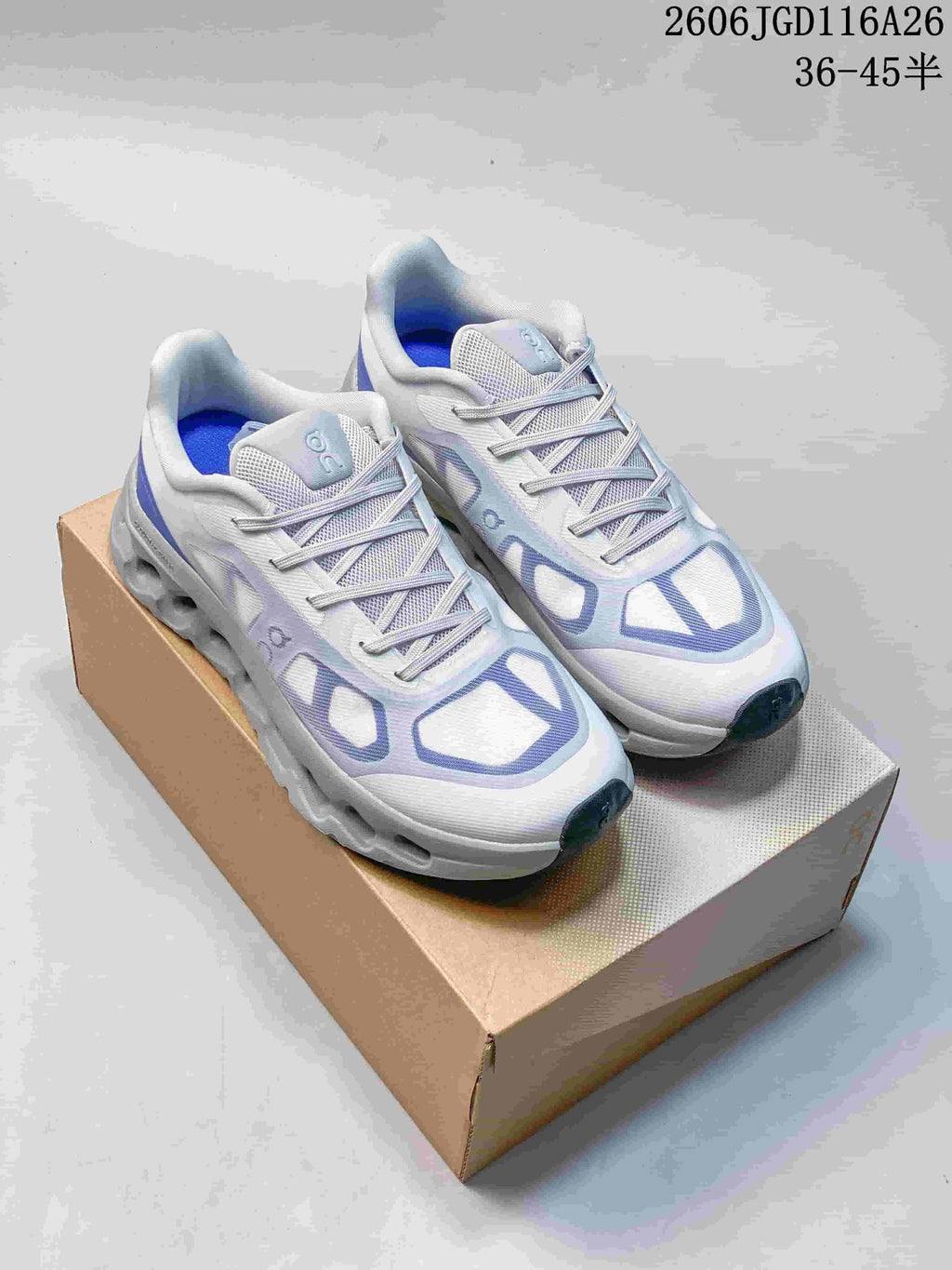 Pair of white On Cloudtilt Remix sneakers with blue and lavender accents, shown on a box