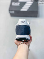 Rear view of the navy and white sneaker showing the padded heel area, EA7 logo, white midsole, and dark textured outsole.