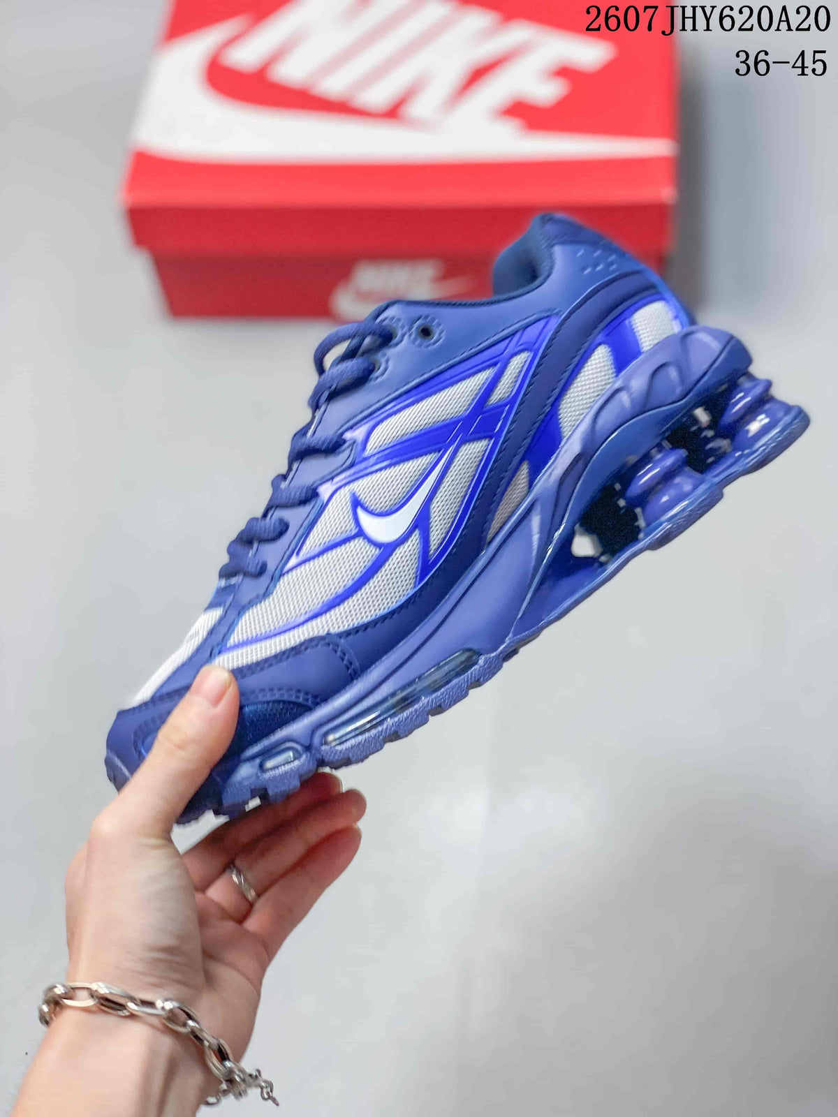 Side view of the blue and white low-top sneaker showing layered panels, mesh-style sections and visible sole cushioning.