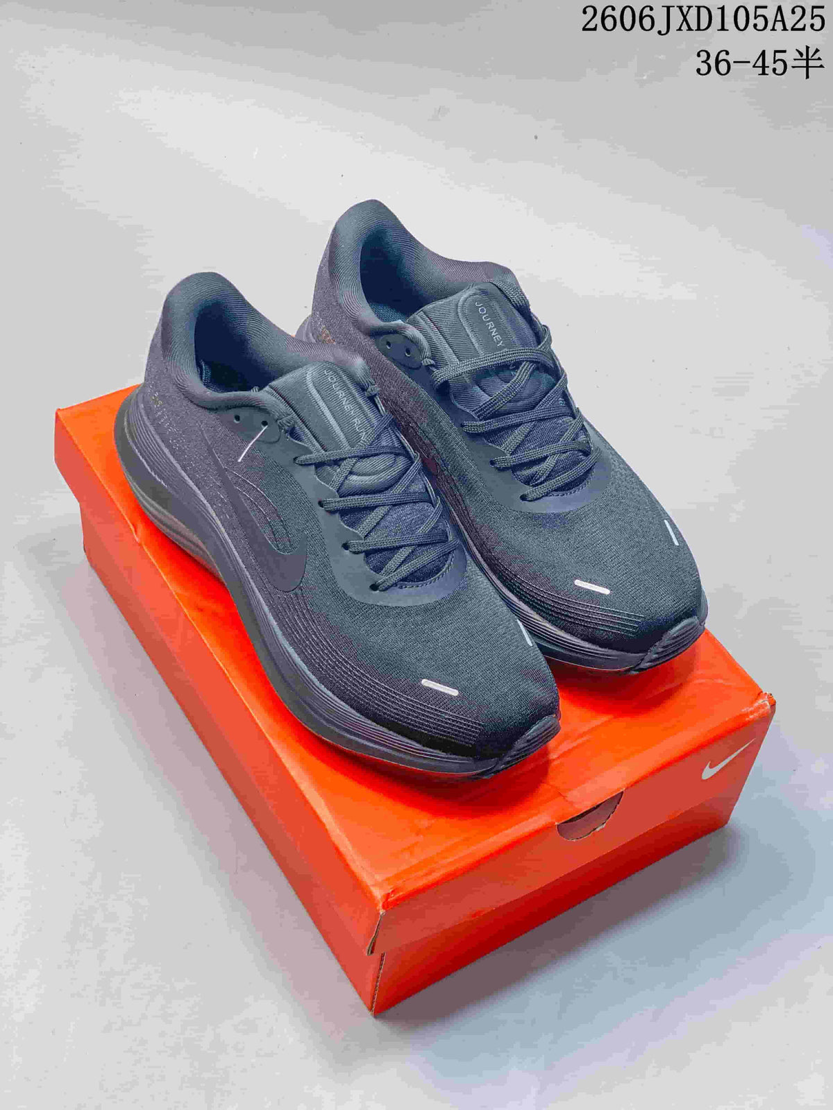 Pair of charcoal Nike Air Zoom Pegasus running shoes displayed on an orange shoe box.