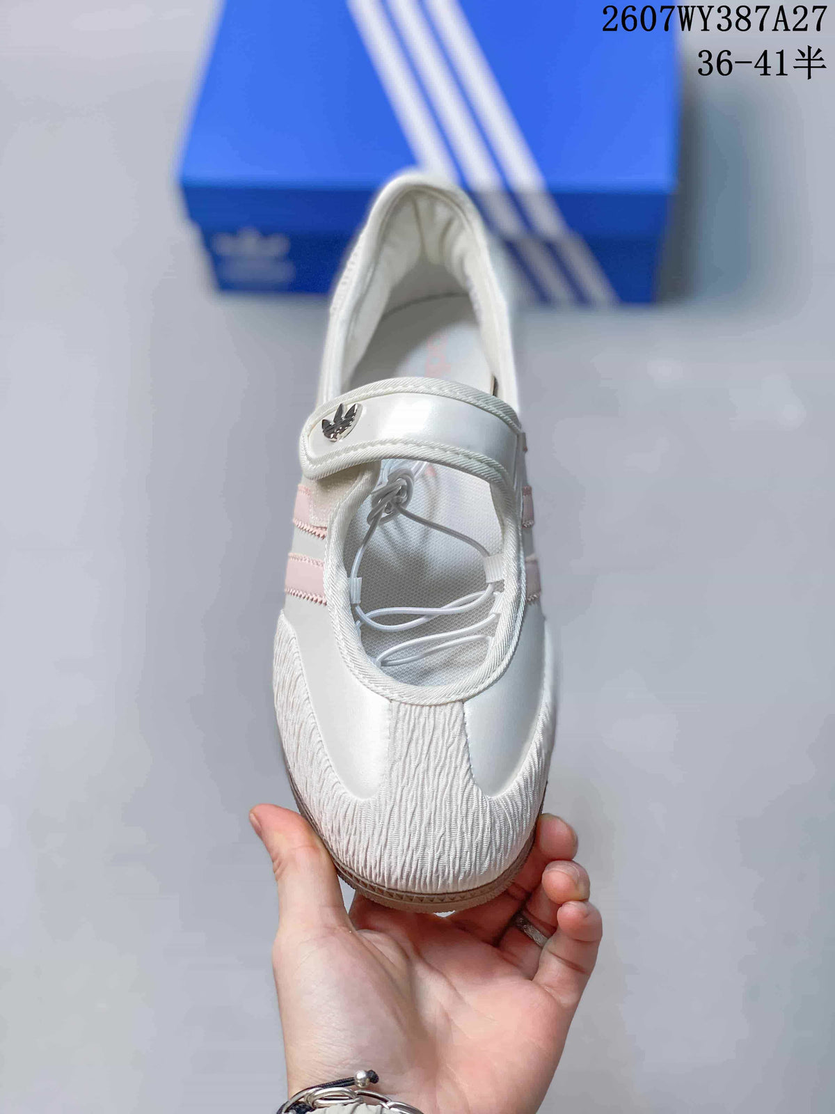 Top view showing the lace-up opening, adjustable Mary Jane strap, rounded toe, and pink side stripes.