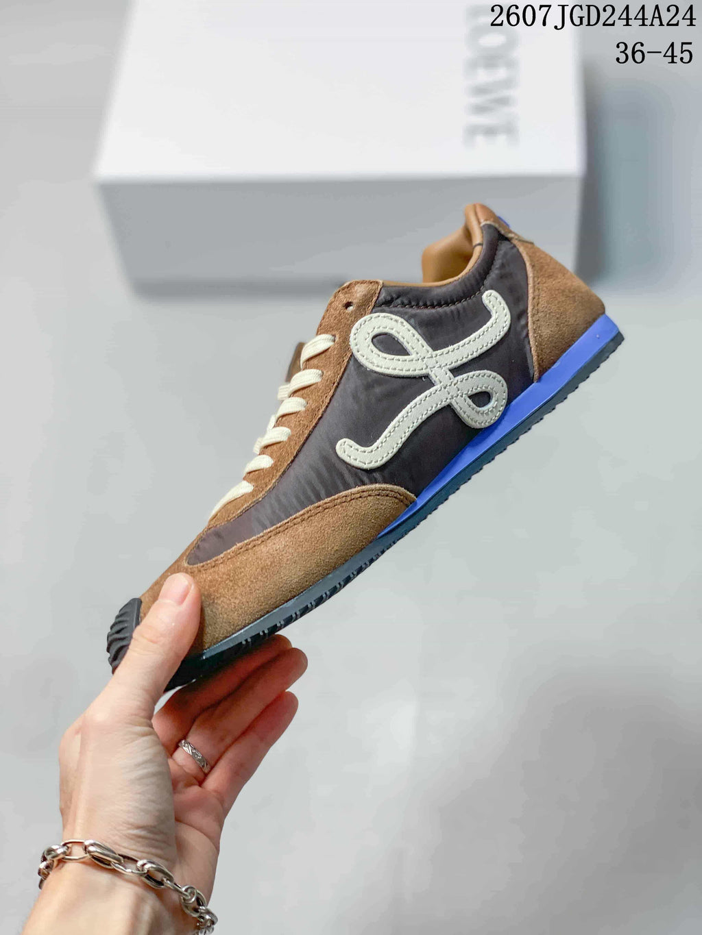 Side profile showing the brown and gray upper, cream side logo detail, blue heel accent, and low-top shape.