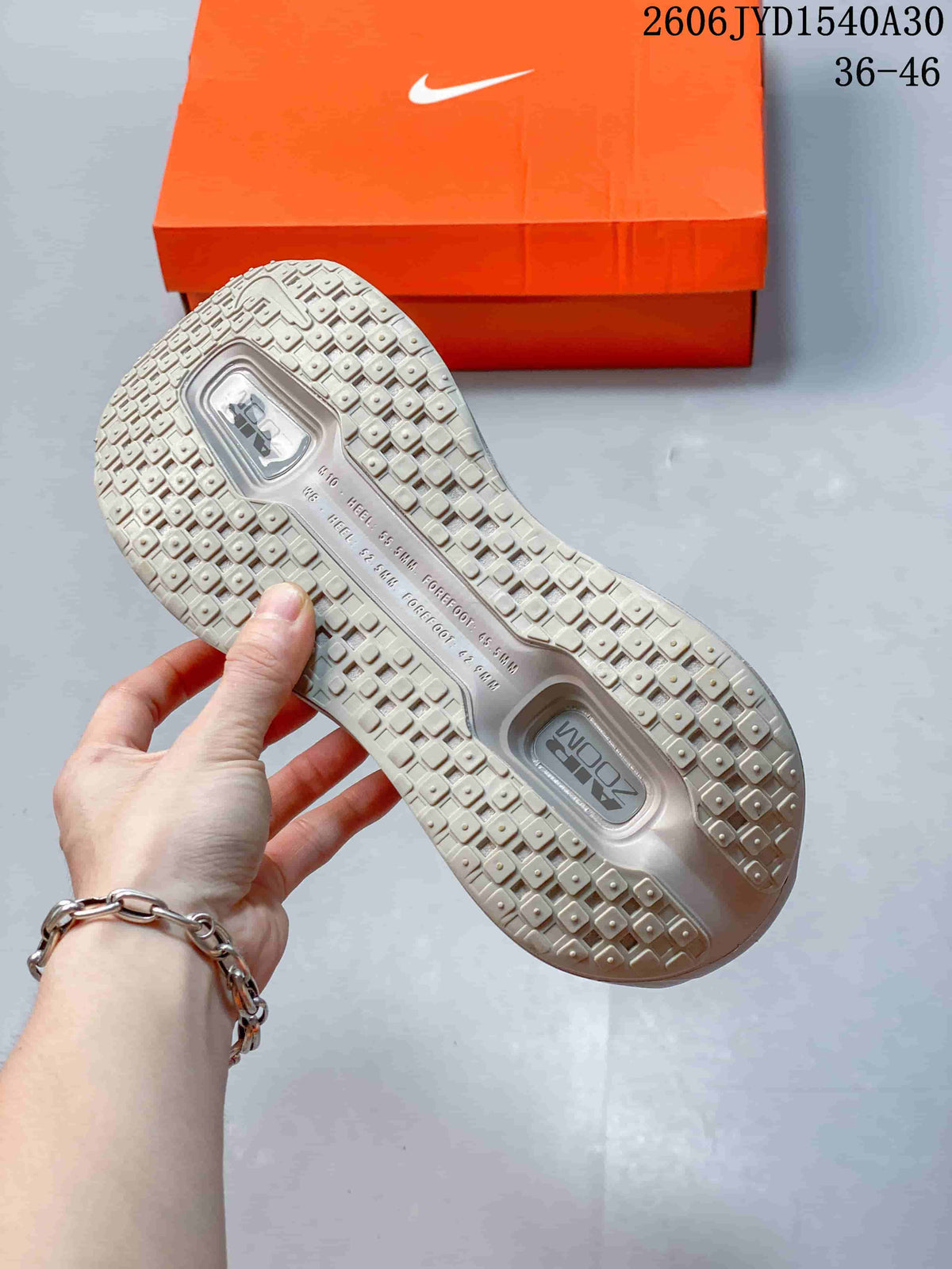Close-up of the patterned outsole and tread on a mauve-gray sneaker