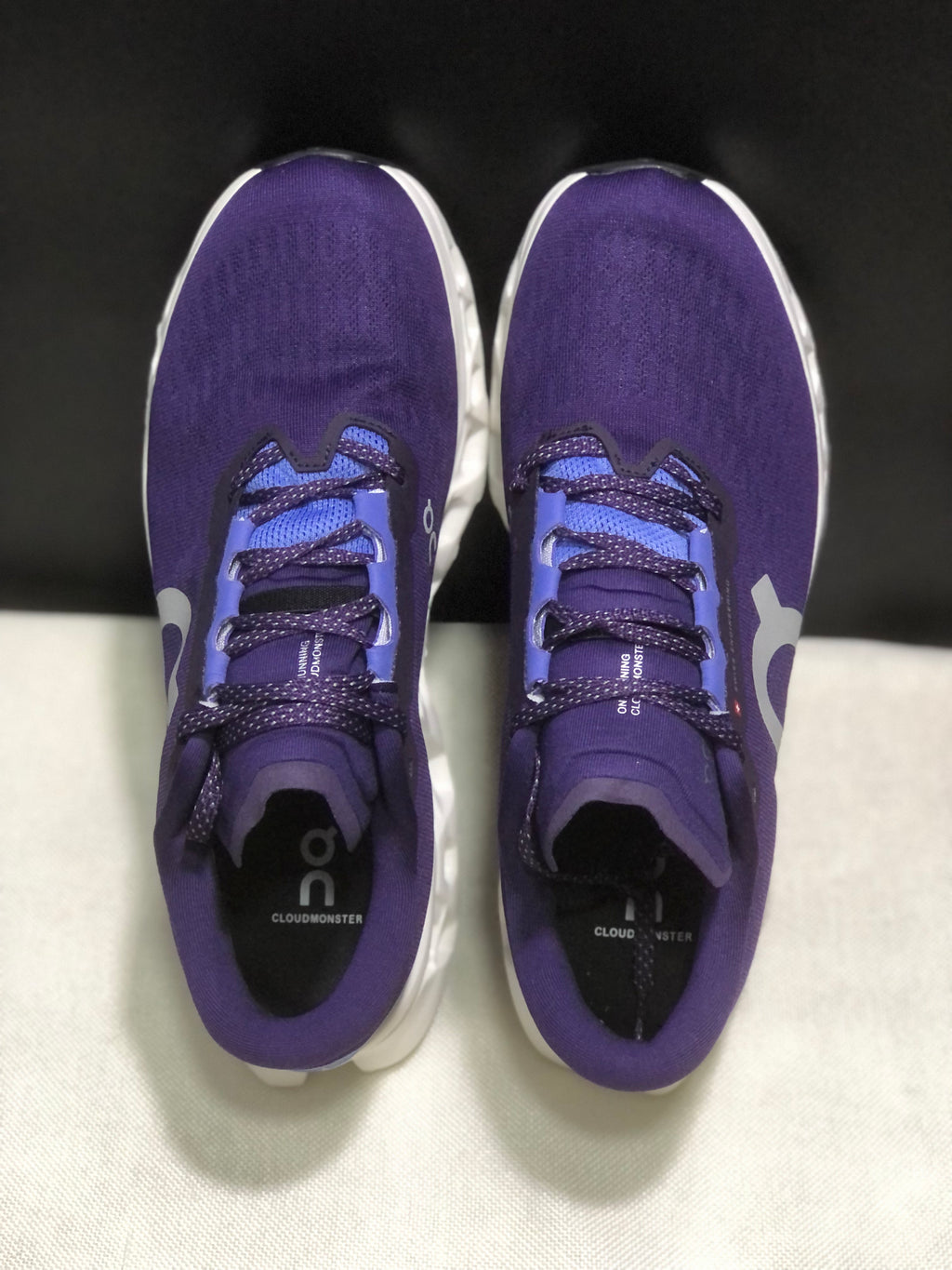Top view of the purple On Cloudmonster 3 shoes showing the lace arrangement, tongues, and footbeds.