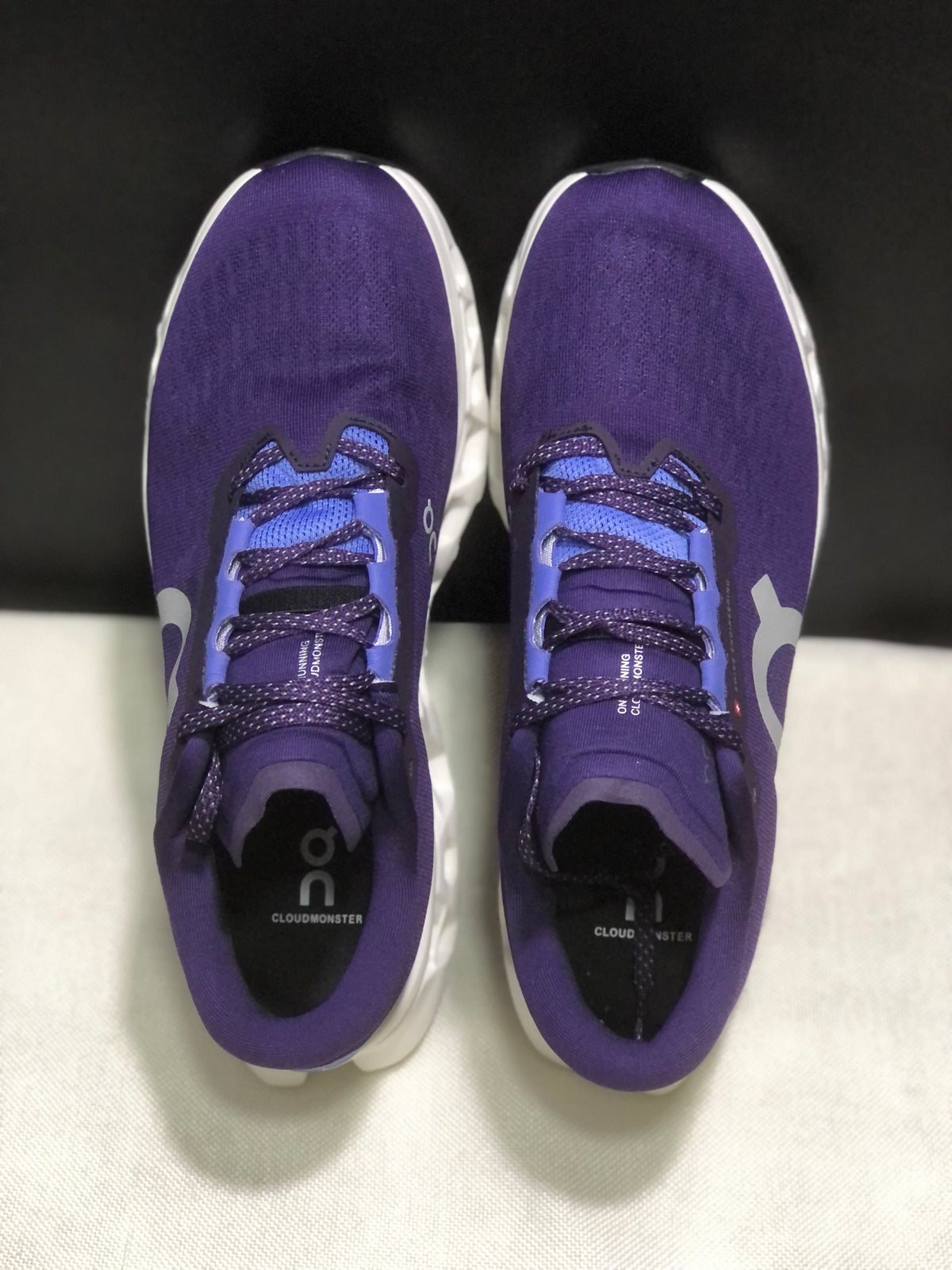 Top view of the purple On Cloudmonster 3 shoes showing the lace arrangement, tongues, and footbeds.