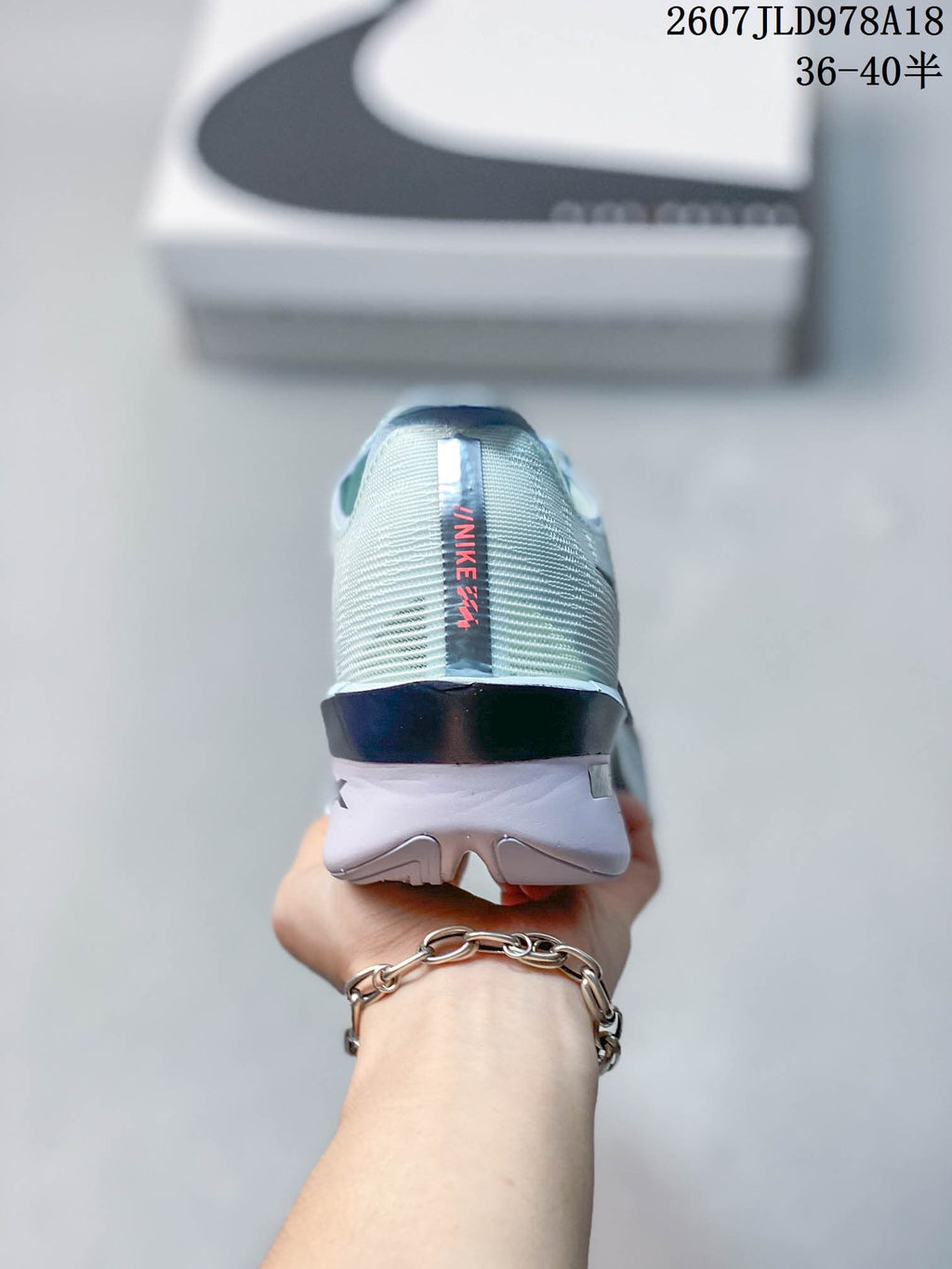 Rear view of the sneaker showing the pale blue textured heel, dark heel clip, and Nike branding.