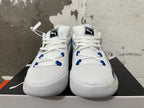 Front view of white Puma sneakers with blue lace-loop accents and black tongue labels.