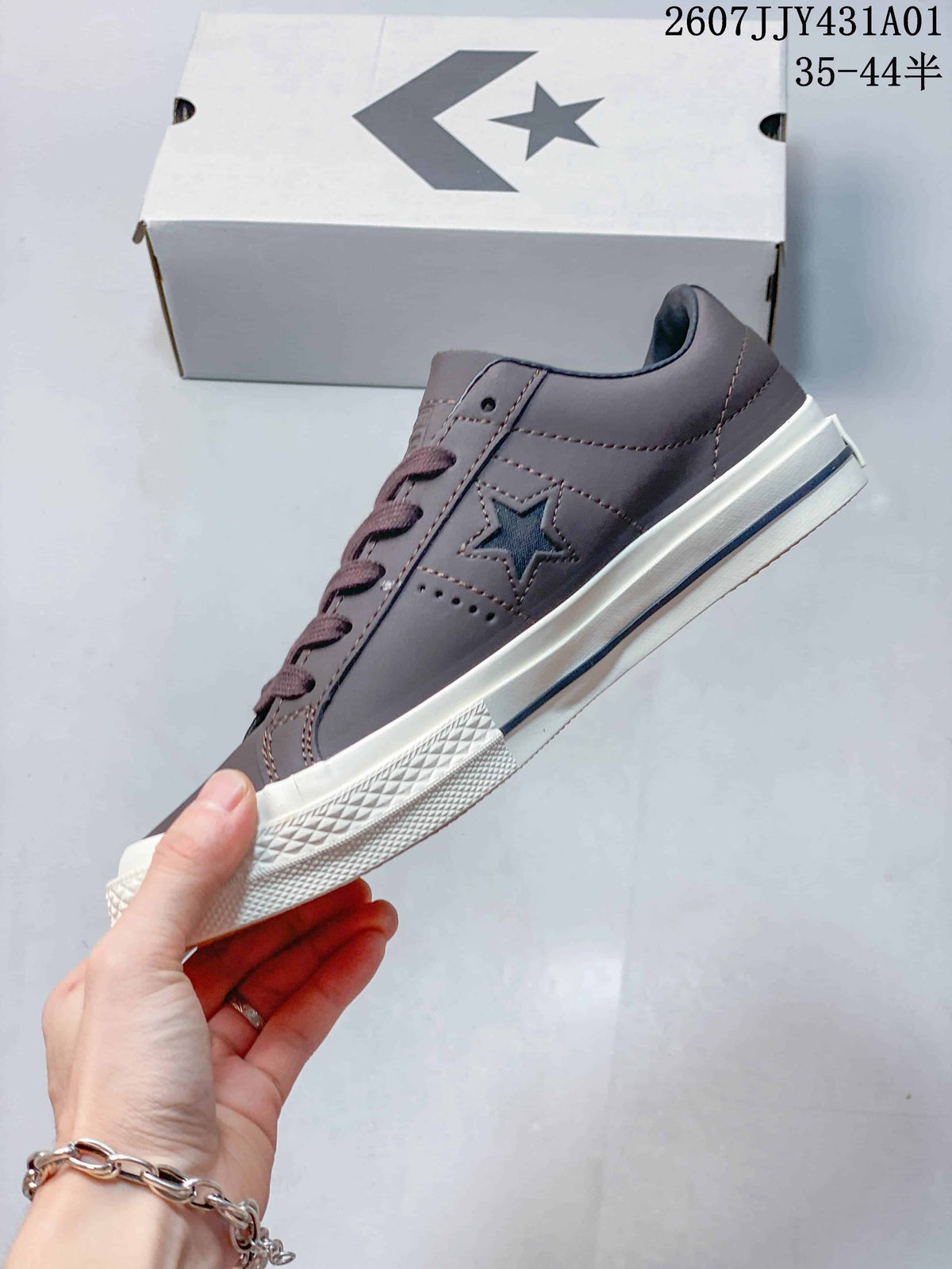 Side view of the gray low-top sneaker with a dark blue star and off-white sole