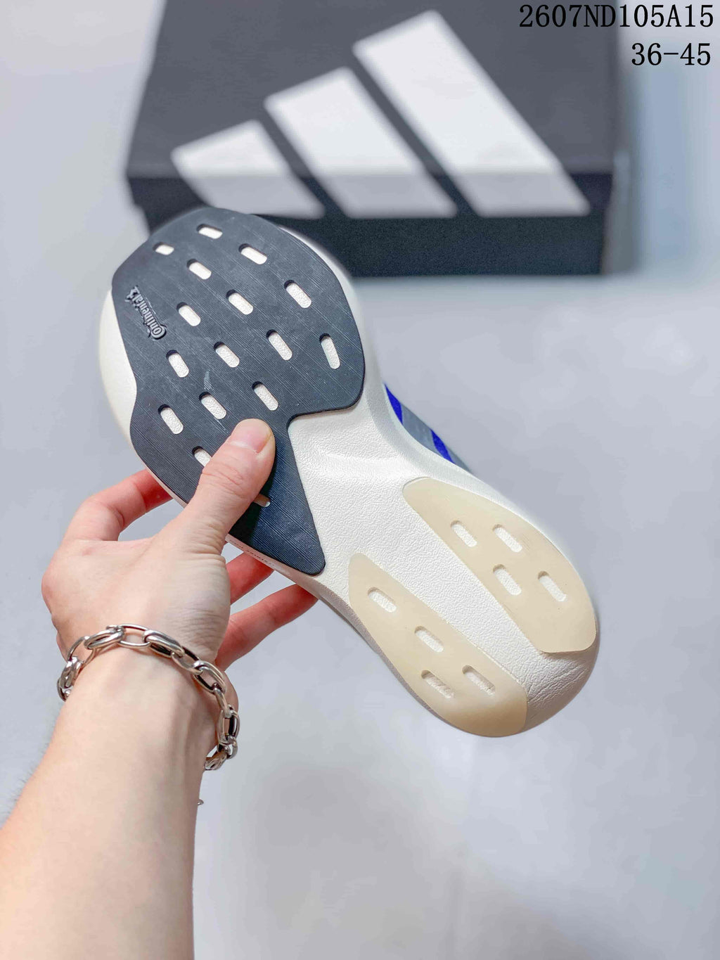 Close view of the sneaker outsole showing dark and light rubber sections with patterned traction grooves.