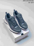 Black Alo Trail sneakers with textured uppers and treaded outsoles on a shoebox.
