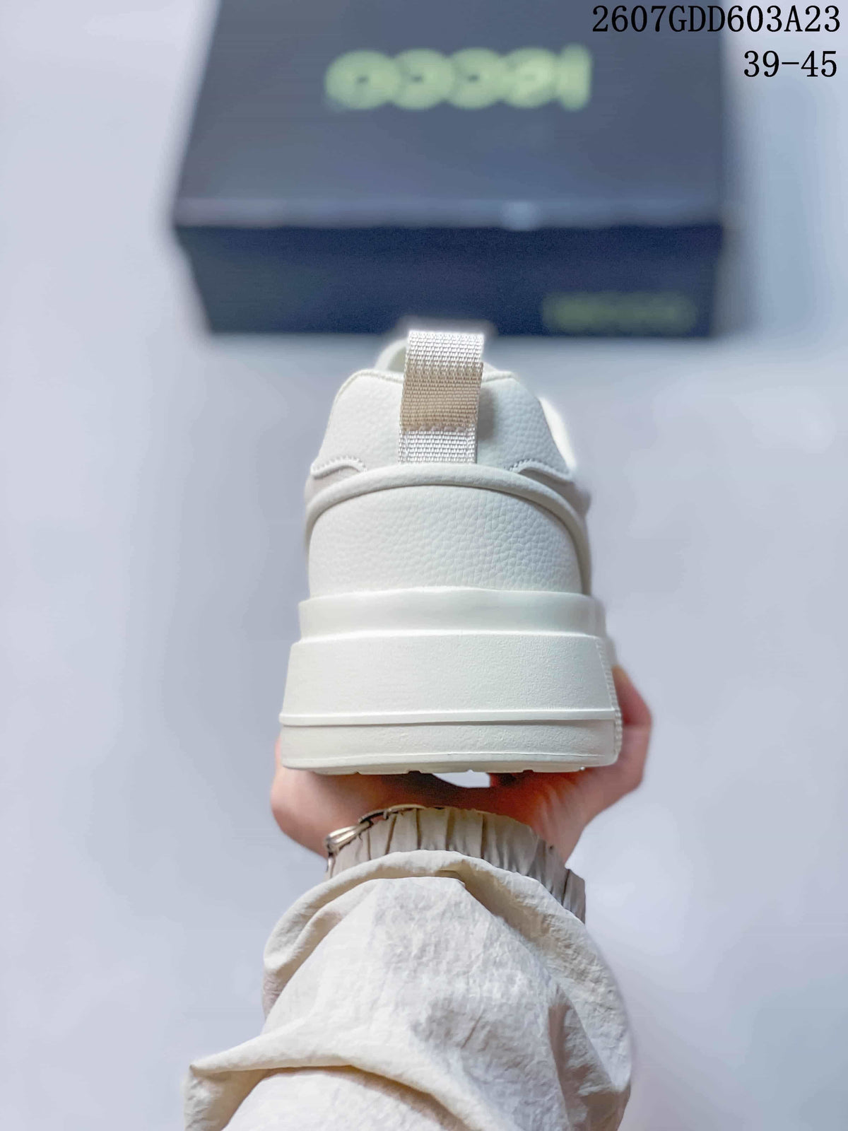 Rear view of the white sneaker showing the padded heel, rear pull tab and layered sole.
