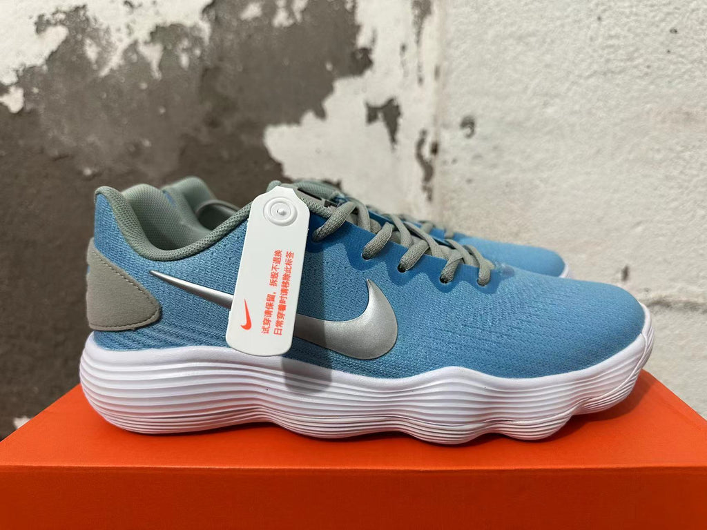 Side view of a blue Nike sneaker with a metallic-toned Swoosh and white ridged sole