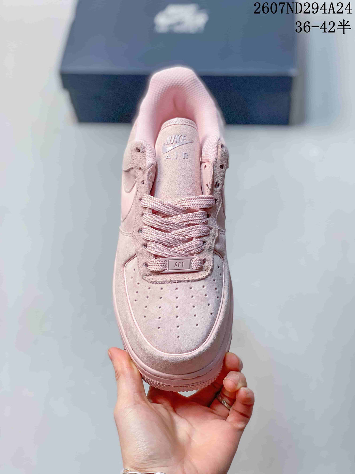 Top view of the soft pink sneaker showing the perforated toe box, laces, and tongue branding.