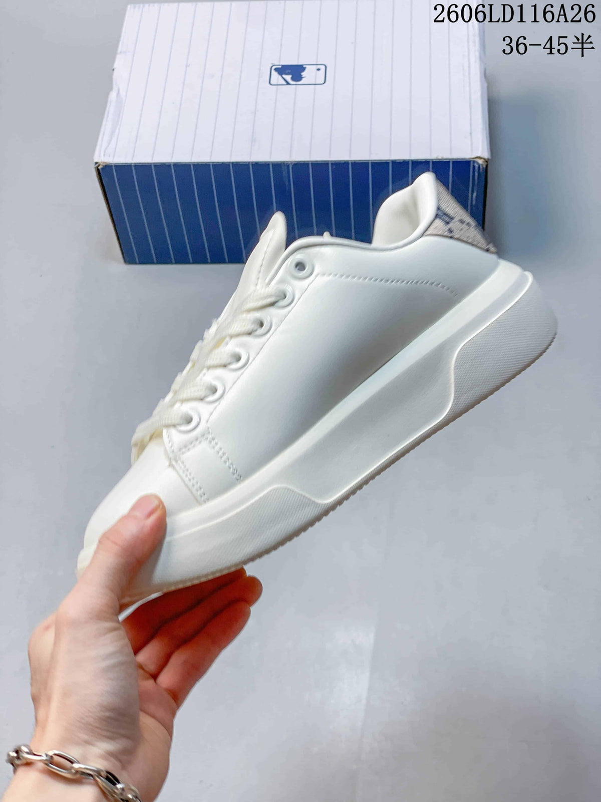 Side view of the white low-top sneaker showing its raised sole and smooth upper.