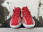 Front view of red basketball shoes with white patterned side panels and white soles.