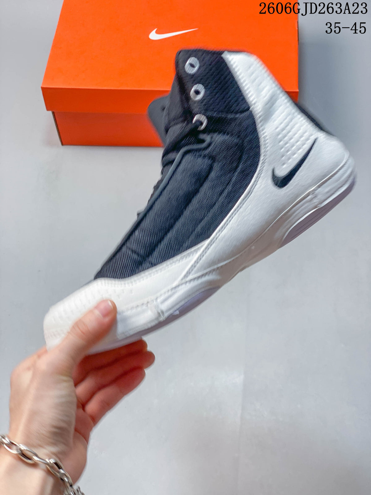 Side view of a navy and white high-top Nike wrestling shoe