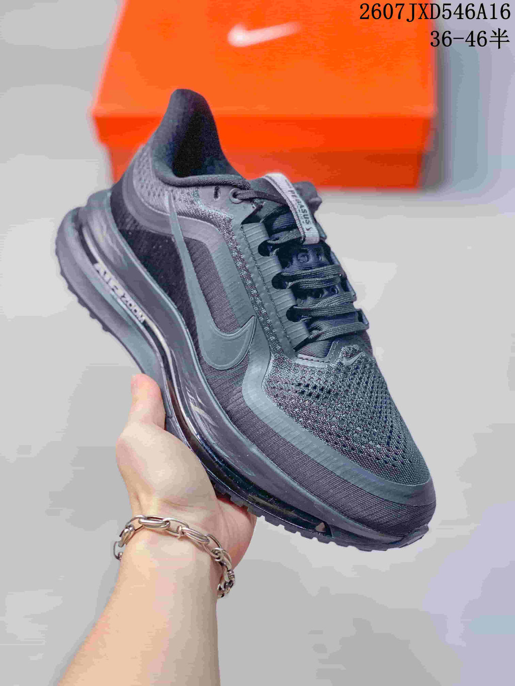 Angled side view showing the black and gray upper, Nike Swoosh, lace fastening, and cushioning midsole.