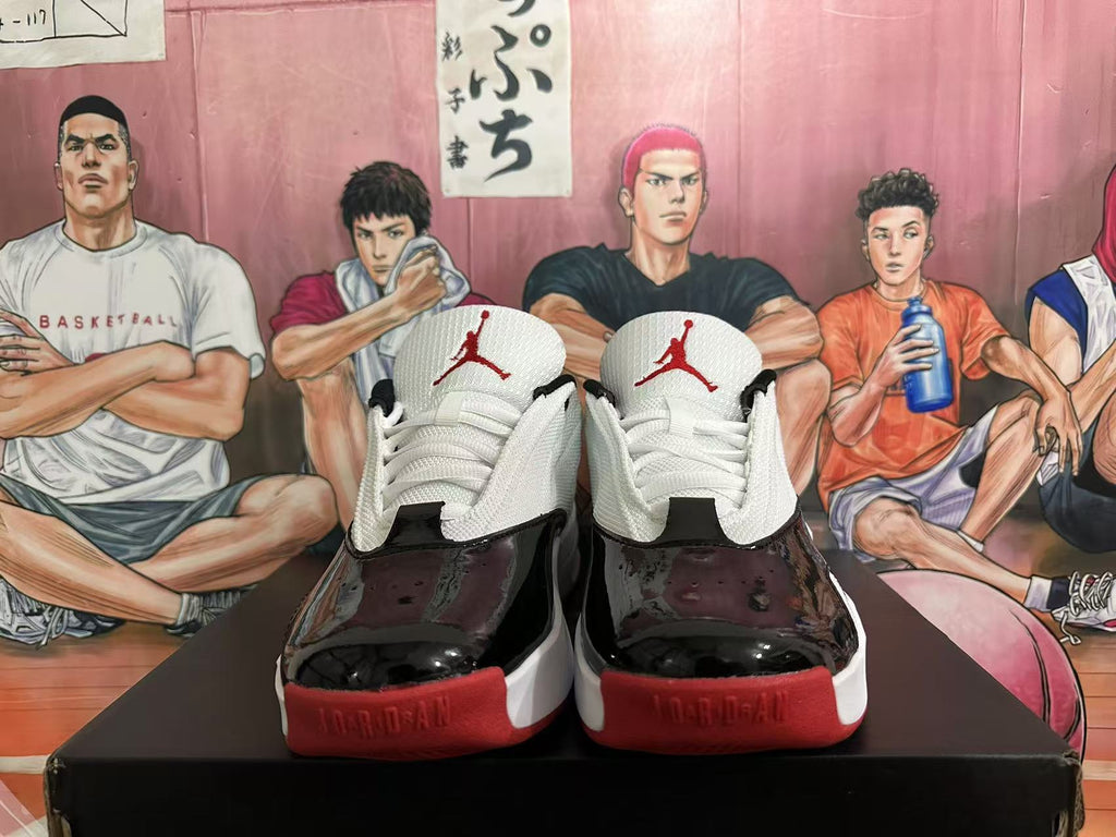 Front view of white, black, and red Jordan basketball sneakers with Jumpman tongue logos.