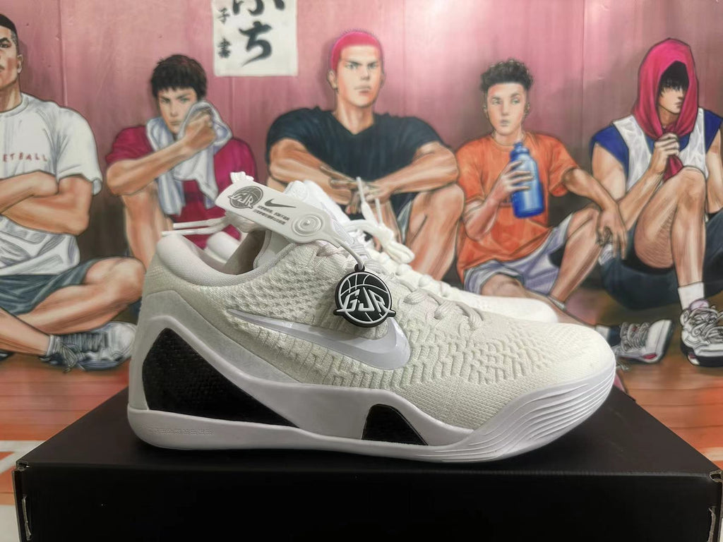 Side view of a white basketball shoe with black panels and visible Nike and Kobe-style branding
