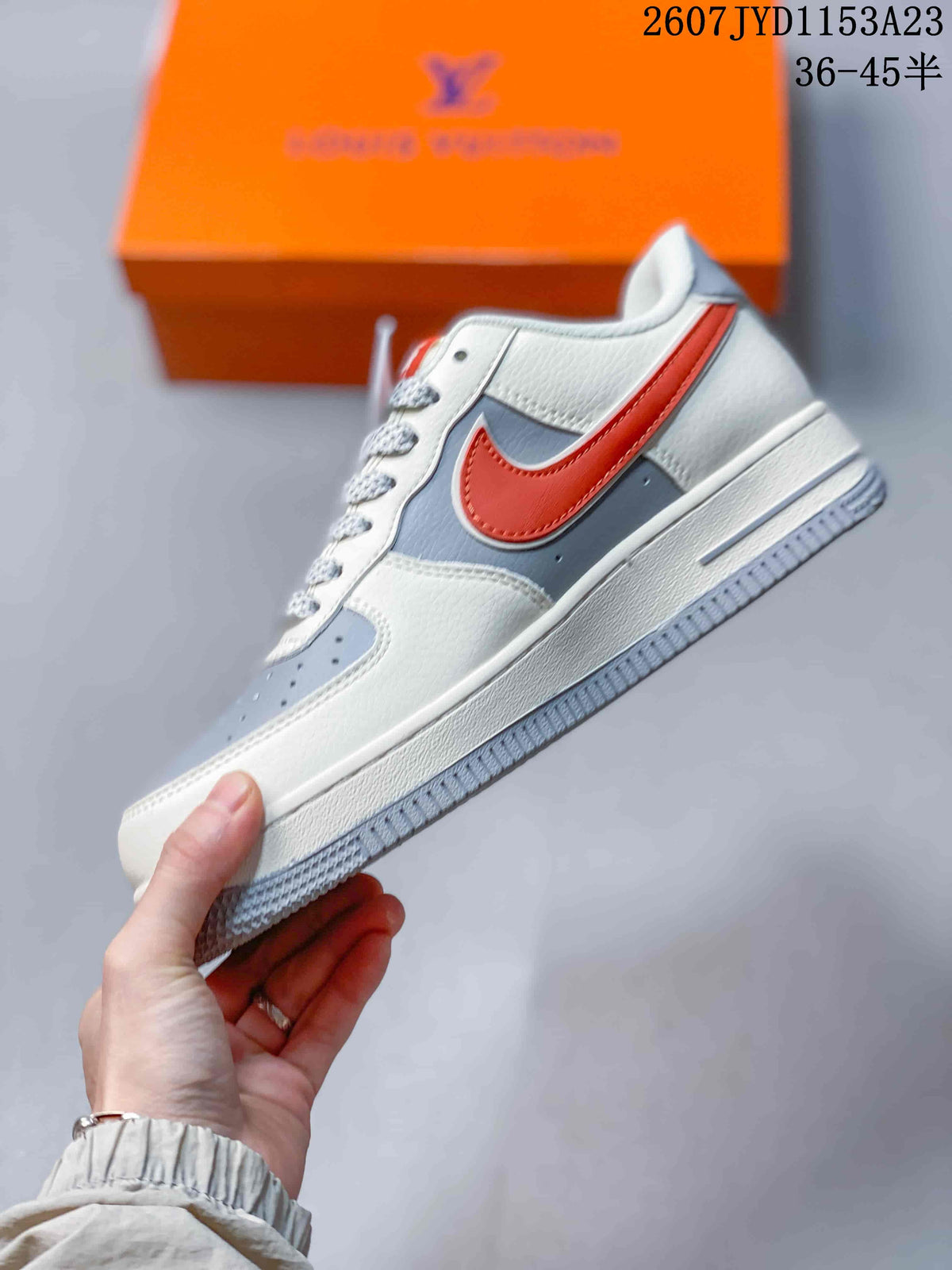 Side profile showing the white and grey upper, red side accent, low-top shape, and layered sole.