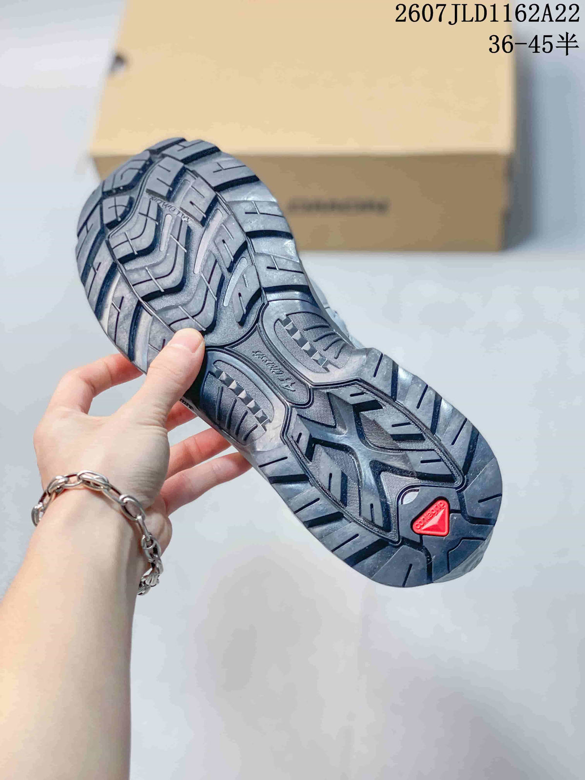 Close view of the Salomon XT-QUEST outsole showing a deep, multi-directional lug pattern and red outsole insert.