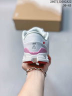 Rear view of the white sneaker showing the padded heel, pink heel accent, On branding, and segmented outsole.
