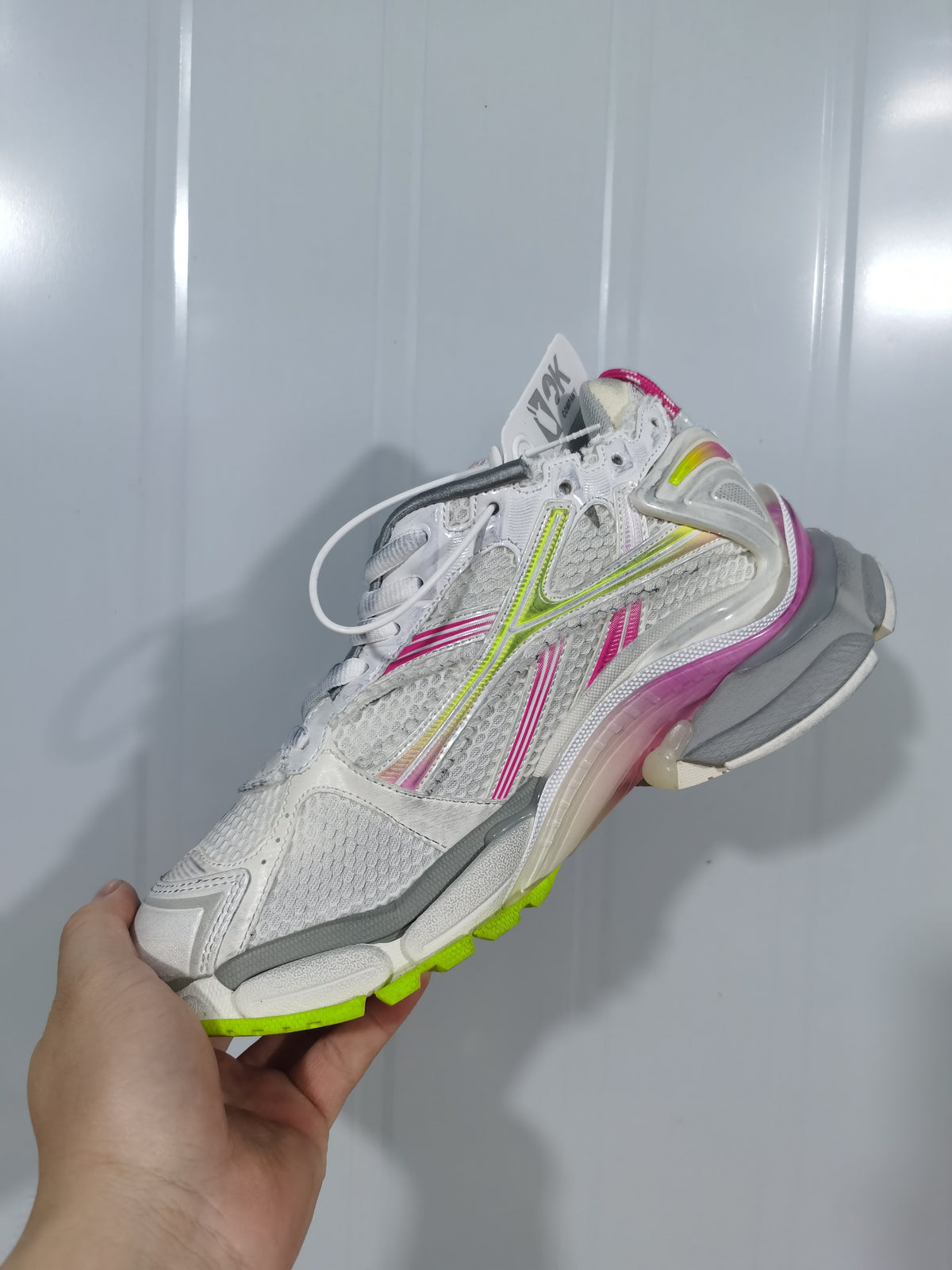 Side view of the white Balenciaga Runner sneaker showing mesh panels, lace fastening, and a multicolor chunky outsole.