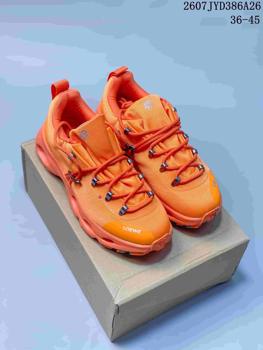 Pair of bright orange On LOEWE series low-top sneakers displayed on a shoebox, with the JYD386A26 style code and 36–45 size range visible.