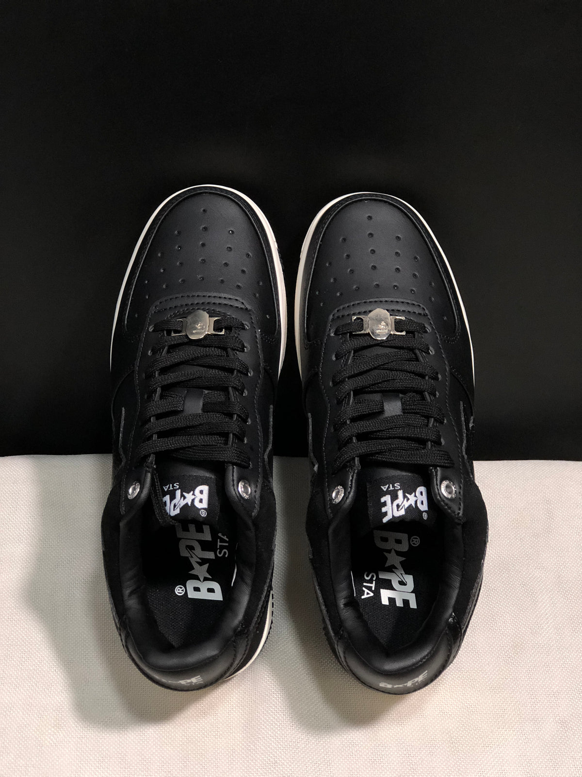 Top view showing the perforated toe boxes, black laces, and padded collars.