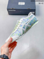 Side view highlighting the floral upper, white signature stripes, pale green midsole, and textured outsole.