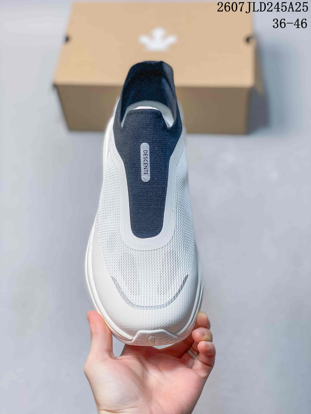 Top view of the white and navy slip-on sneaker showing the lace-free opening and textured forefoot.
