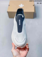 Top view of the white and navy slip-on sneaker showing the lace-free opening and textured forefoot.