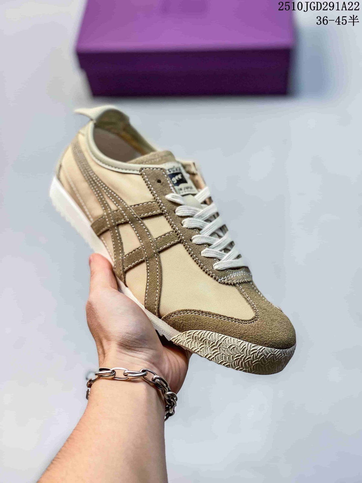 Beige and brown Onitsuka Tiger sneaker held in hand, showing contrast stripes and a textured outsole.
