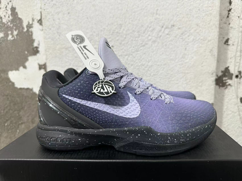 Side view of a purple and black Nike Kobe basketball shoe with a Swoosh and speckled sole.
