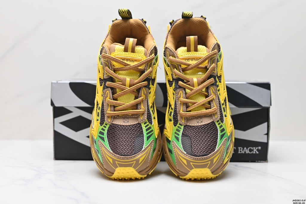 Front view of yellow, brown, green, and black Off-White Be Right Back sneakers with rounded toes and lace-up fronts, displayed in front of the product box.