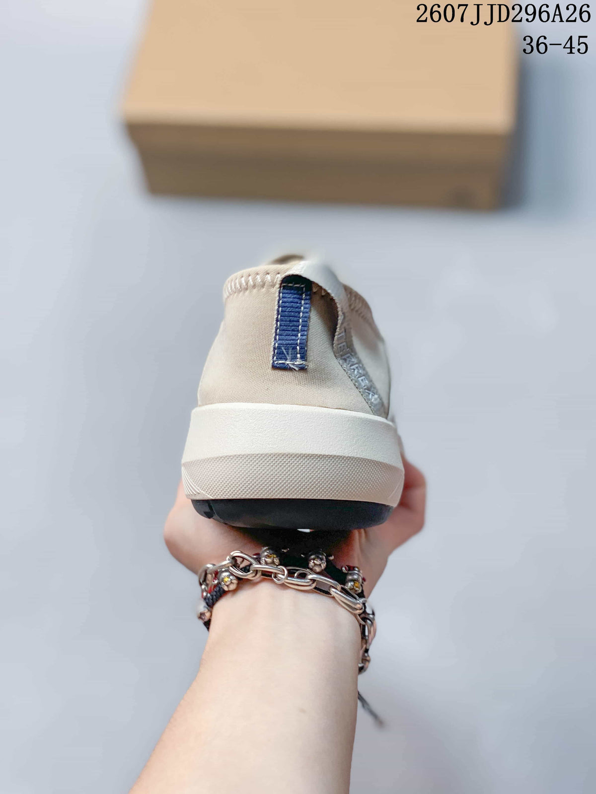 Rear view of the light gray slip-on sneaker showing the heel pull tab, white midsole, and black outsole.
