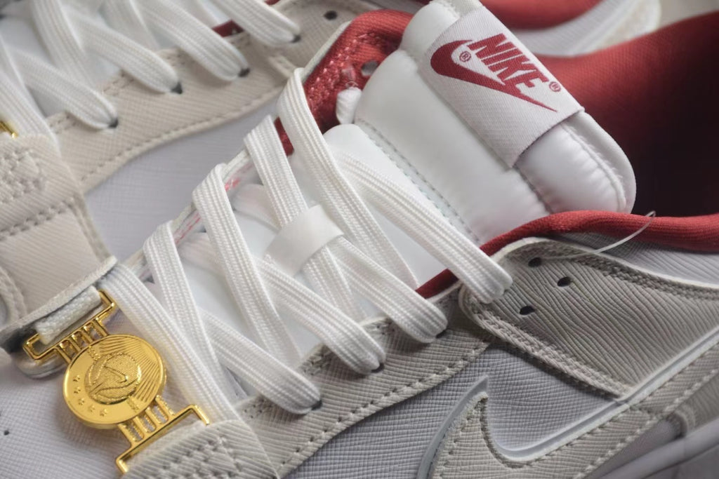 Close-up of the white laces, Nike tongue label, textured off-white panels, and gold-tone clasp detail.
