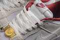 Close-up of the white laces, Nike tongue label, textured off-white panels, and gold-tone clasp detail.
