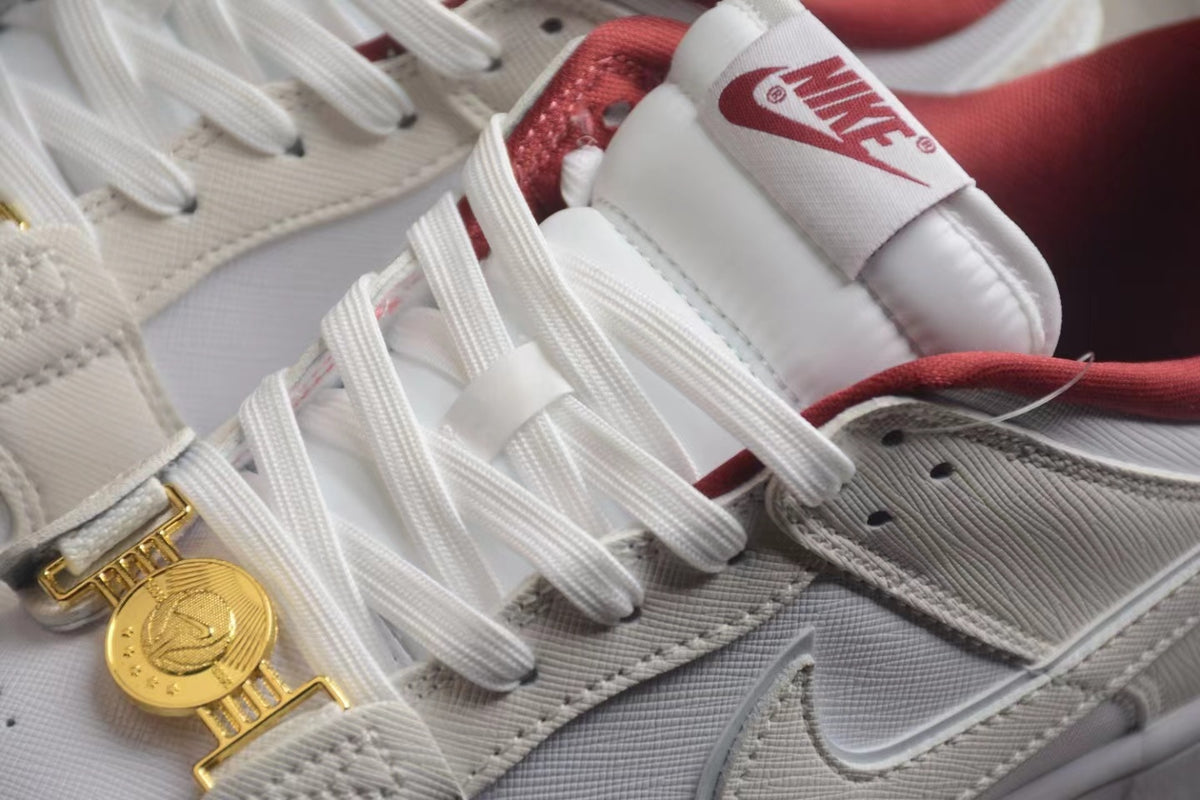 Close-up of the white laces, Nike tongue label, textured off-white panels, and gold-tone clasp detail.