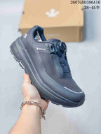 Angled side view of the black sneaker showing visible GORE-TEX branding, BOA-style dial closure, and lugged outsole.
