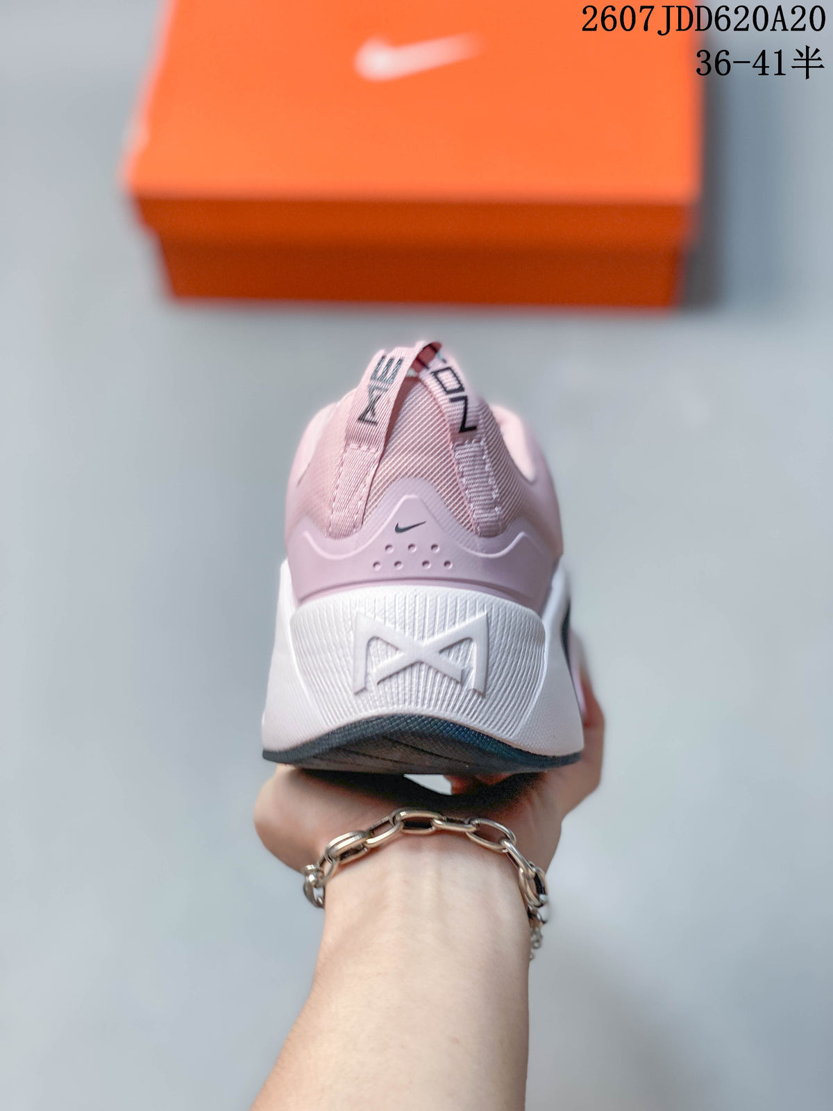 Rear view of the pink and white training shoe showing the padded heel, Nike branding, and sculpted white midsole.